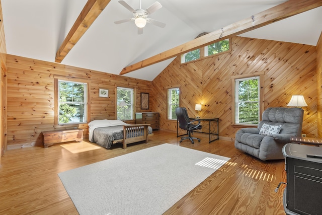 bedroom with multiple windows, wood walls, and light wood-type flooring