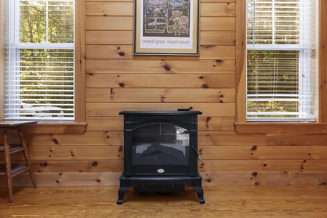 detailed view of wood walls, a wood stove, and wood finished floors