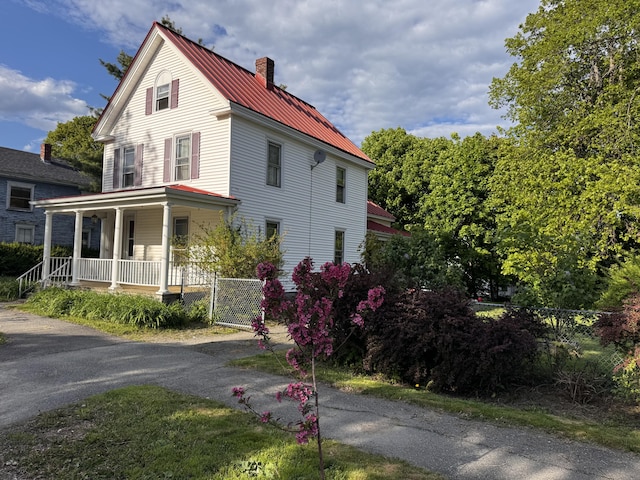 21 Fern St, Bangor, ME 04401 - view of property exterior featuring a porch, a chimney, metal roof, and a standing seam roof