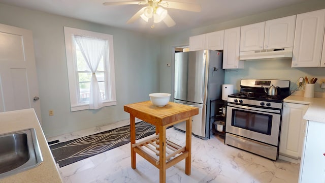 21 Fern St, Bangor, ME 04401 - kitchen with stainless steel appliances, under cabinet range hood, light marble finish flooring, and white cabinets