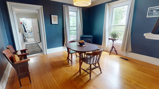 21 Fern St, Bangor, ME 04401 - dining room featuring a wood stove, light wood finished floors, plenty of natural light, and baseboards