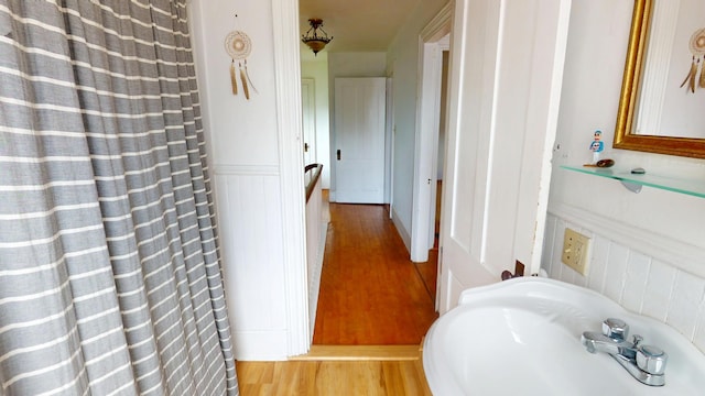 21 Fern St, Bangor, ME 04401 - bathroom with wood finished floors, a sink, a decorative wall, a wainscoted wall, and a shower with curtain