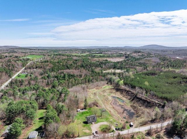 aerial view of property and surrounding area with a heavily wooded area and a mountainous background