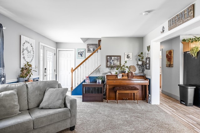 living area with stairs and wood finished floors