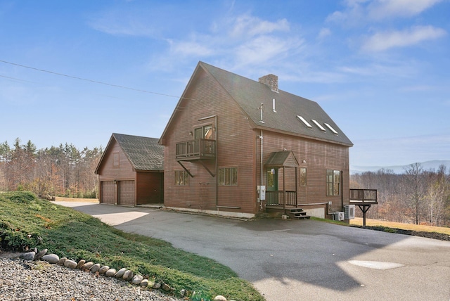 237 River Rd, Avon, ME 04966 - view of home's exterior featuring a balcony, a chimney, a shingled roof, and cooling unit