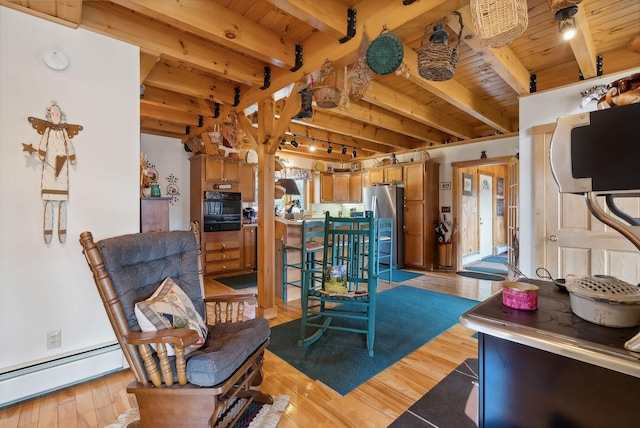 237 River Rd, Avon, ME 04966 - living room featuring wood ceiling, a baseboard radiator, beamed ceiling, and light wood finished floors