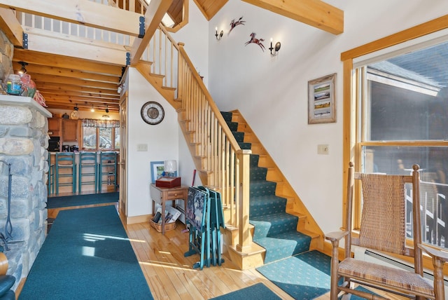 237 River Rd, Avon, ME 04966 - stairs with wood-type flooring, beamed ceiling, and a baseboard radiator