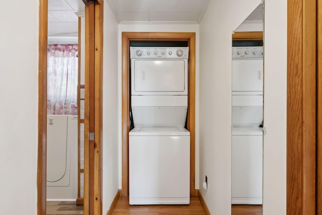237 River Rd, Avon, ME 04966 - washroom featuring stacked washer / dryer, wood finished floors, crown molding, and baseboards