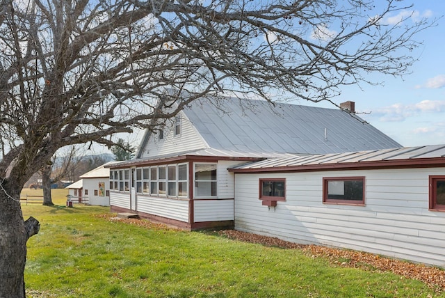 237 River Rd, Avon, ME 04966 - view of side of property featuring a sunroom, metal roof, a lawn, and a chimney