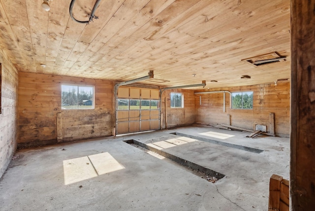 237 River Rd, Avon, ME 04966 - miscellaneous room with wood ceiling, wood walls, a garage, plenty of natural light, and unfinished concrete flooring