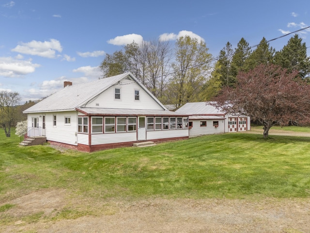 237 River Rd, Avon, ME 04966 - rear view of house with a sunroom, a lawn, a chimney, and metal roof