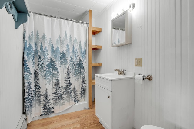 237 River Rd, Avon, ME 04966 - bathroom with wood finished floors, vanity, a baseboard heating unit, and a shower with curtain