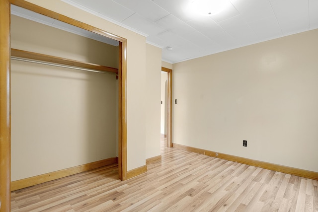 237 River Rd, Avon, ME 04966 - unfurnished bedroom featuring light wood-style floors, crown molding, a closet, and baseboards