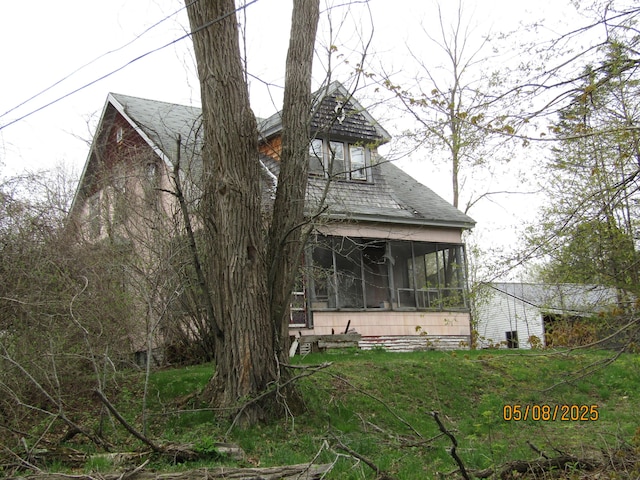 8 Water St, Milo, ME 04463 - view of front of house with a sunroom, roof with shingles, and a front lawn