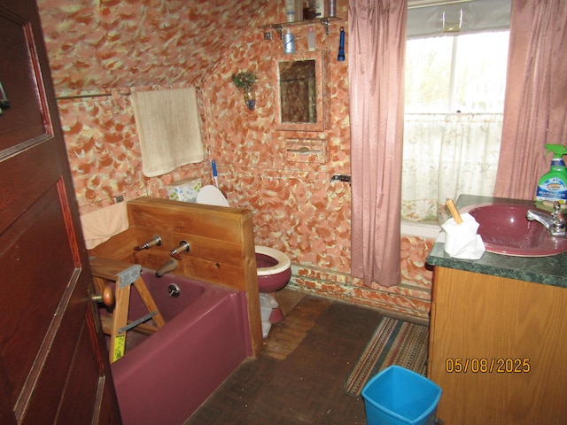 8 Water St, Milo, ME 04463 - bathroom featuring toilet, wood finished floors, a garden tub, vanity, and lofted ceiling