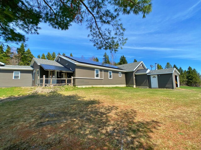 44 Martin Ln, Eagle Lake, ME 04739 - rear view of property featuring roof mounted solar panels and a lawn