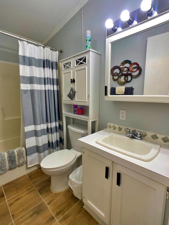 bathroom with toilet, vanity, crown molding, and wood finished floors