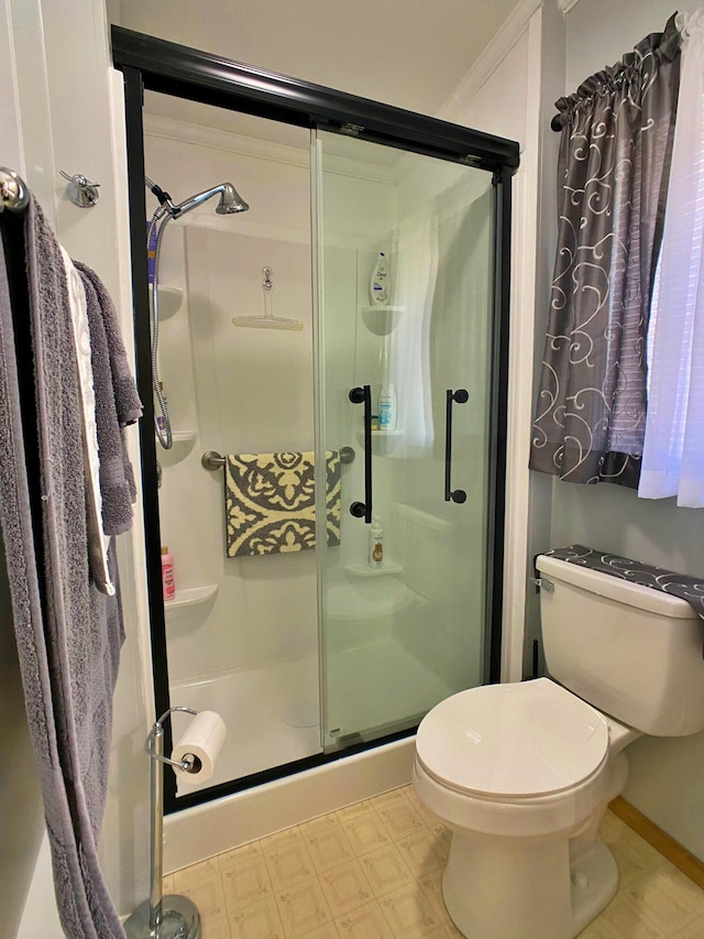 bathroom with tile patterned floors, a shower stall, and toilet