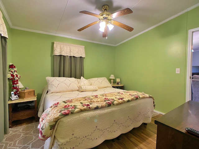 bedroom featuring wood finished floors, crown molding, and ceiling fan