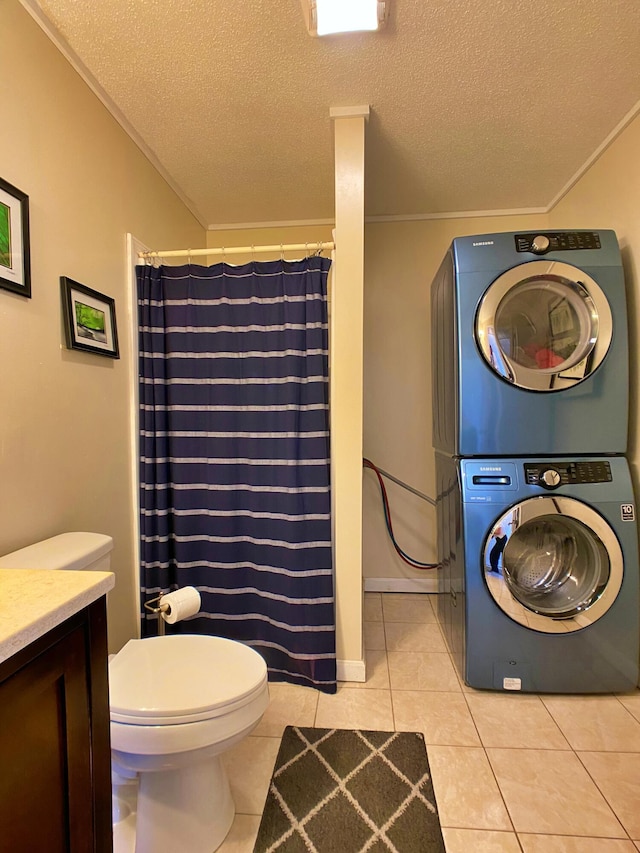 full bath featuring estacked washer and dryer, crown molding, a textured ceiling, tile patterned floors, and toilet