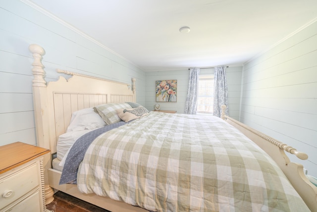 bedroom with ornamental molding and wood walls