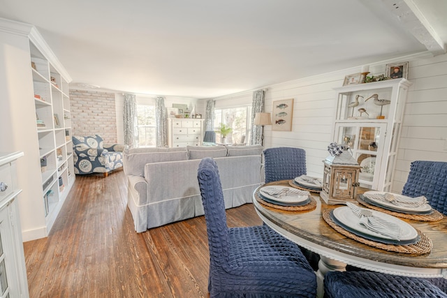 dining space featuring wood finished floors and wood walls