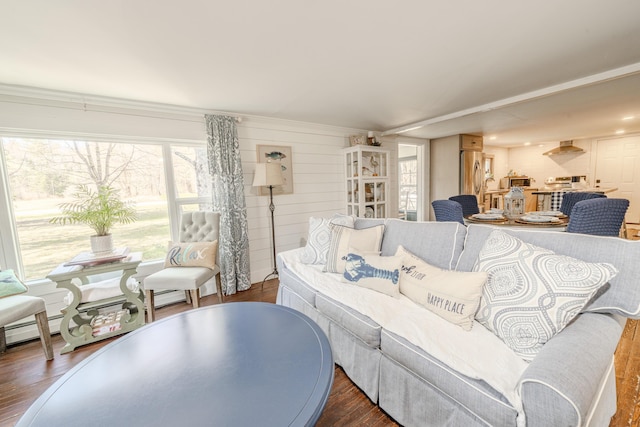 living area featuring plenty of natural light, wood finished floors, and a baseboard heating unit