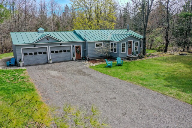 single story home featuring a standing seam roof, metal roof, driveway, a front yard, and a garage