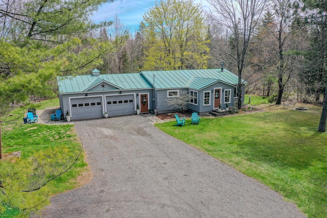 ranch-style home featuring a standing seam roof, dirt driveway, an attached garage, metal roof, and a front yard