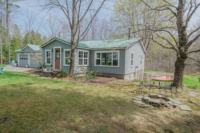single story home with a fire pit, a front lawn, and metal roof