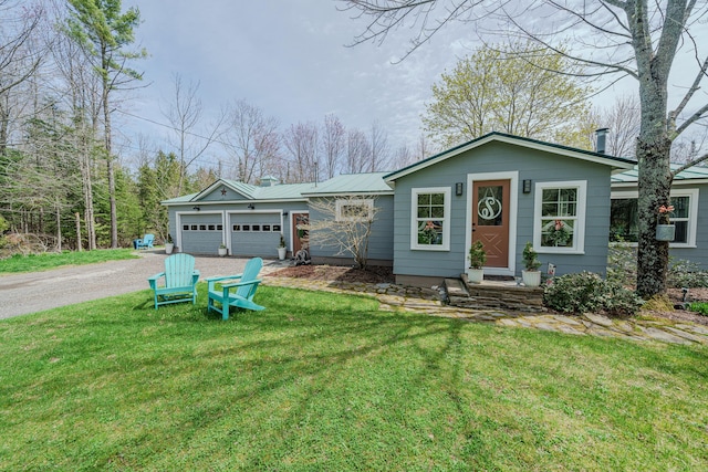 ranch-style house featuring an attached garage, driveway, a front lawn, and metal roof