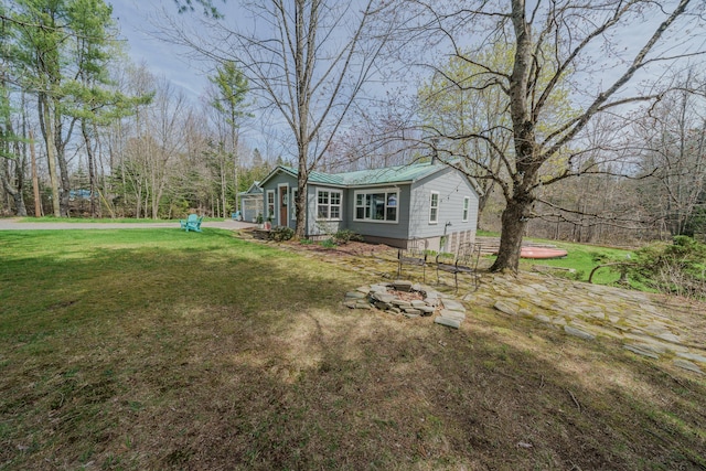 view of green lawn with an outdoor fire pit