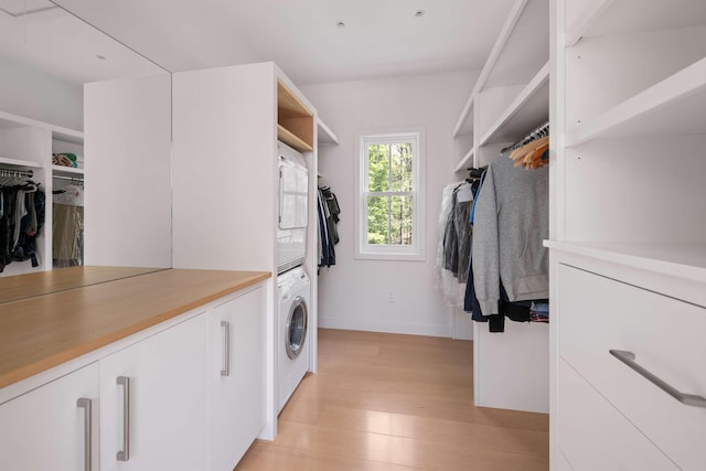 3 Bristol Ln, York, ME 03909 - laundry room featuring cabinet space, stacked washing machine and dryer, light wood finished floors, and baseboards