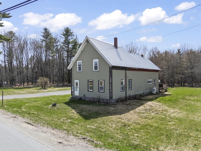 1568 Hill Rd, Canaan, ME 04924 - view of property exterior featuring a chimney, a lawn, and metal roof