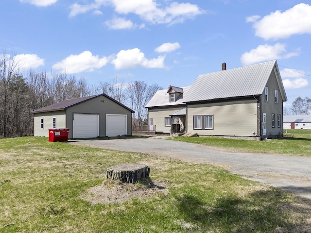 1568 Hill Rd, Canaan, ME 04924 - view of front facade featuring a detached garage, an outdoor structure, metal roof, a front yard, and a chimney