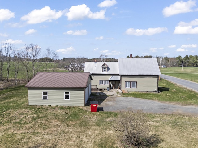 1568 Hill Rd, Canaan, ME 04924 - view of front of property featuring metal roof, a front yard, an outbuilding, and asphalt driveway