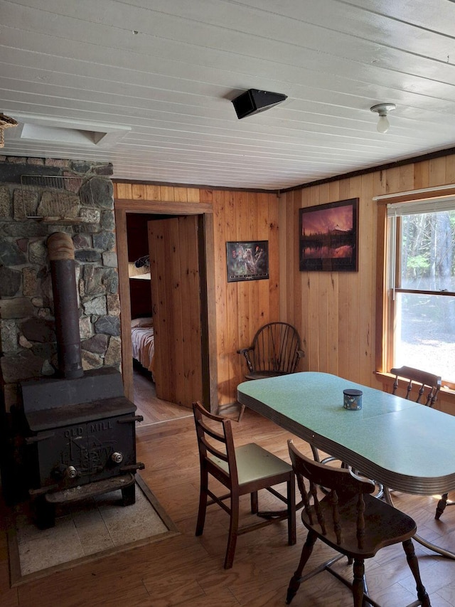 27 Kingman Beach Rd, Osborn, ME 04605 - dining area featuring a wood stove, wooden walls, and wood finished floors