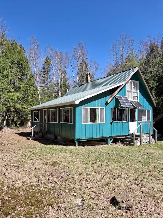 27 Kingman Beach Rd, Osborn, ME 04605 - rear view of house featuring metal roof, a chimney, entry steps, and a yard