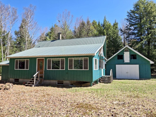 27 Kingman Beach Rd, Osborn, ME 04605 - view of front of home featuring metal roof, entry steps, a front yard, and an outdoor structure