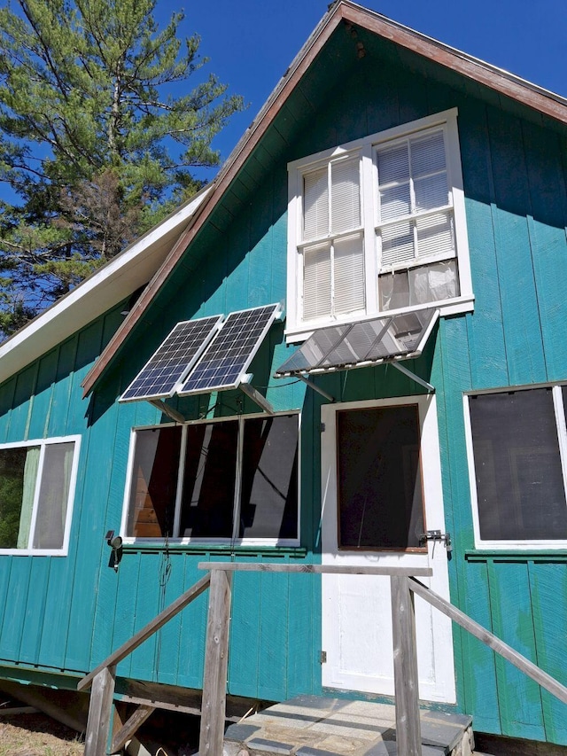 27 Kingman Beach Rd, Osborn, ME 04605 - view of property exterior with board and batten siding and solar panels