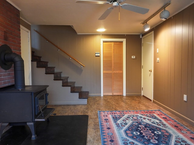 11 Moreau Ave, Lewiston, ME 04240 - entrance foyer with baseboards, a wood stove, a ceiling fan, and stairs