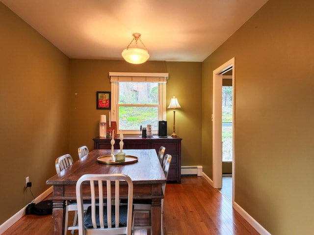 11 Moreau Ave, Lewiston, ME 04240 - dining area featuring a baseboard radiator, dark wood-type flooring, and baseboards
