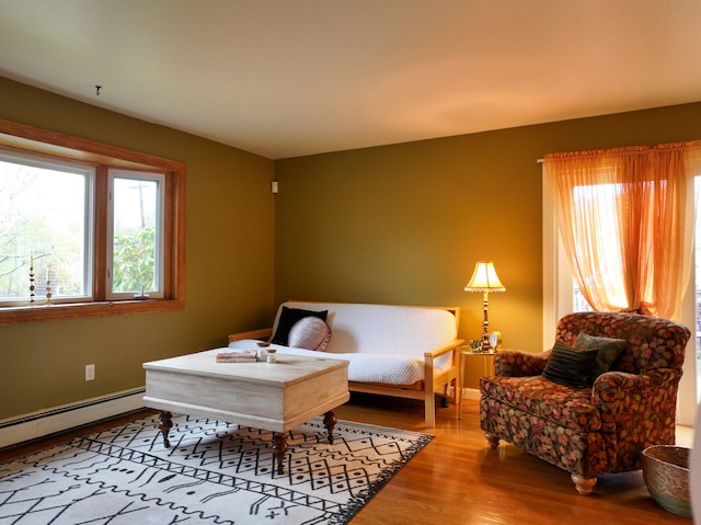 11 Moreau Ave, Lewiston, ME 04240 - living area with plenty of natural light, wood finished floors, a baseboard heating unit, and baseboards