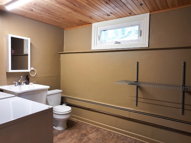 11 Moreau Ave, Lewiston, ME 04240 - bathroom featuring baseboard heating, toilet, wood ceiling, a sink, and wood finished floors