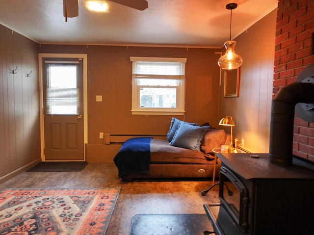 11 Moreau Ave, Lewiston, ME 04240 - bedroom featuring a baseboard radiator, ceiling fan, and a wood stove