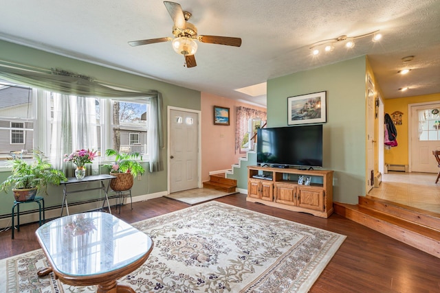 living room with stairway, a baseboard radiator, healthy amount of natural light, and wood finished floors