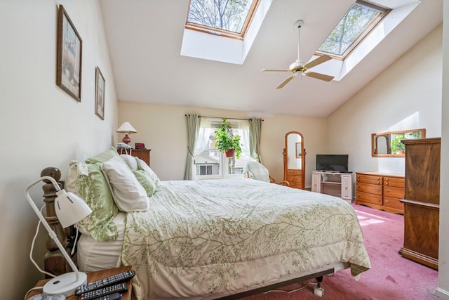carpeted bedroom with a skylight, high vaulted ceiling, and ceiling fan