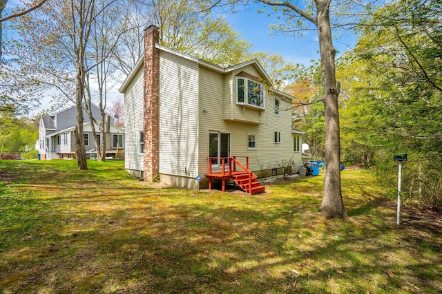 rear view of property with a chimney and a yard