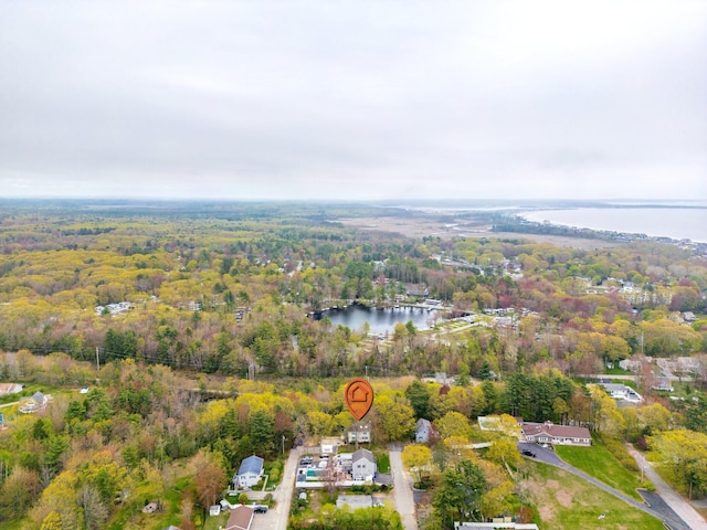 aerial view of property and surrounding area with a heavily wooded area and a large body of water