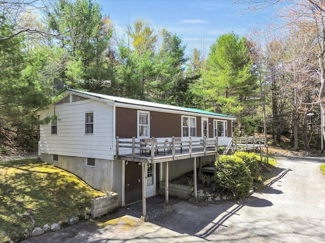 1270 Main St, Mount Desert, ME 04660 - view of front of property with a deck, asphalt driveway, and metal roof